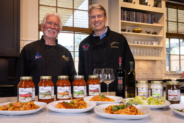 Germano's chefs posing with an array of Germano's products and dishes